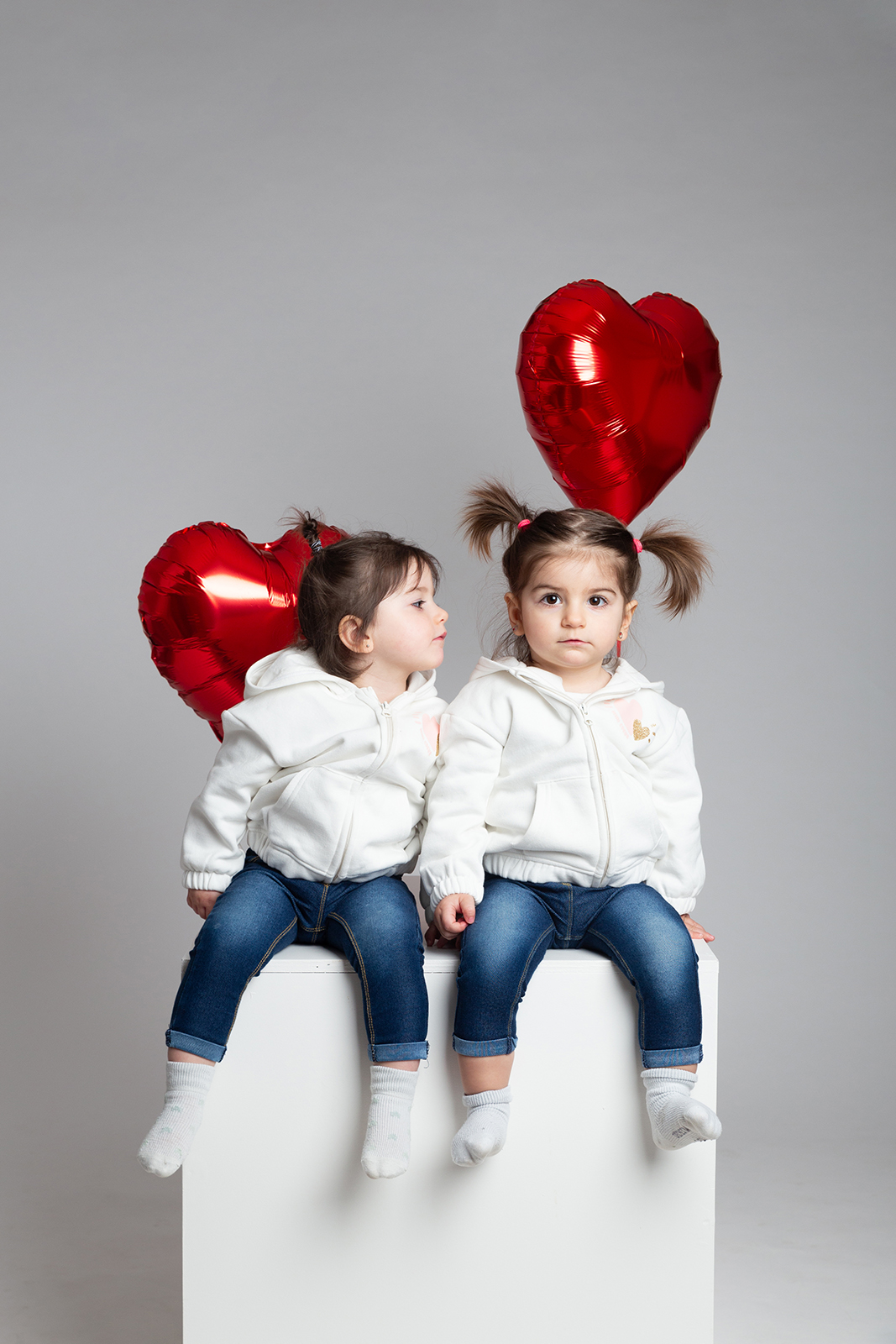 Des jumelles avec des ballons pour la séance photo famille au studio Emilie Lemele à Manosque